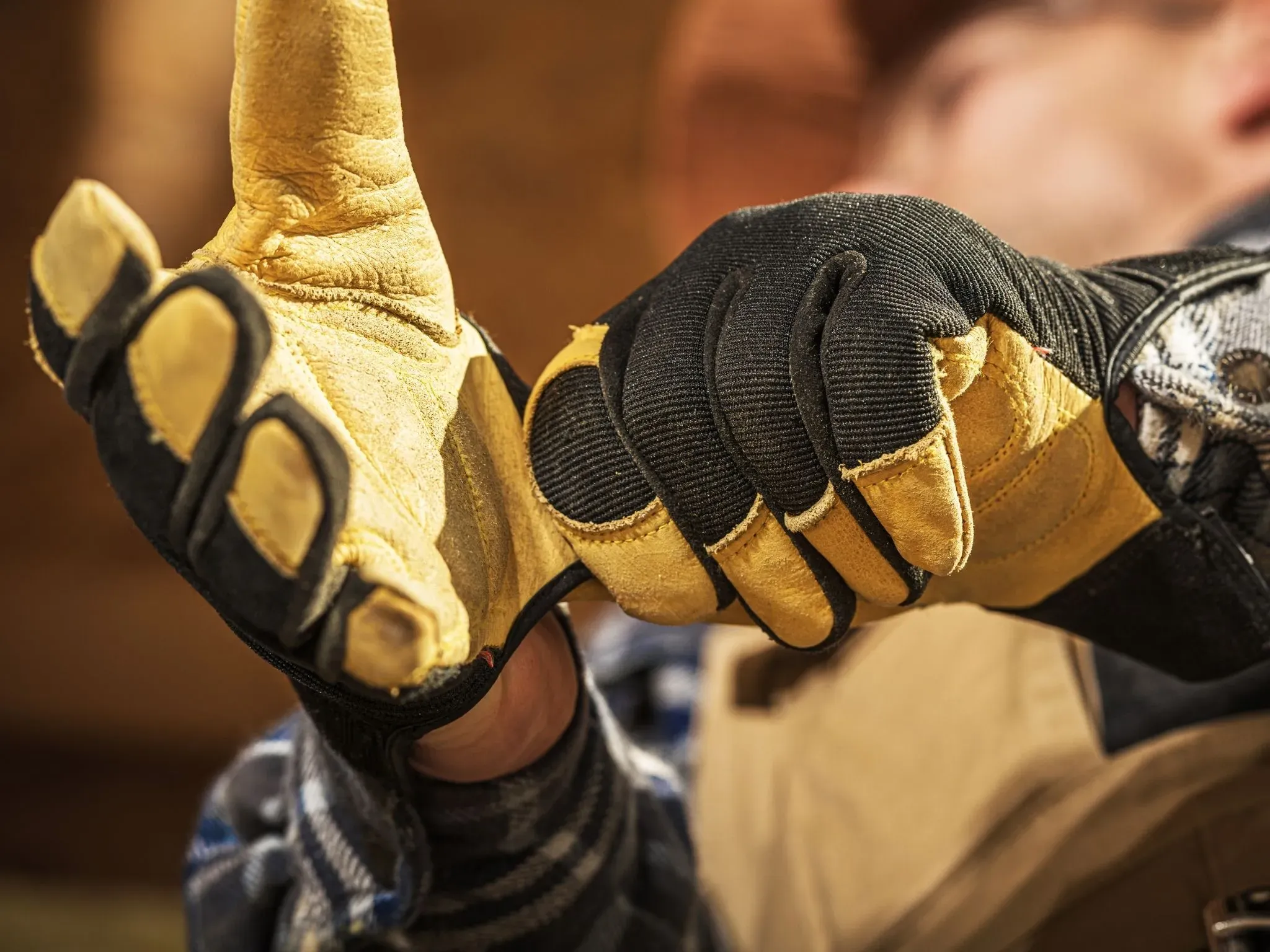 Person zieht sich Arbeitshandschuhe an