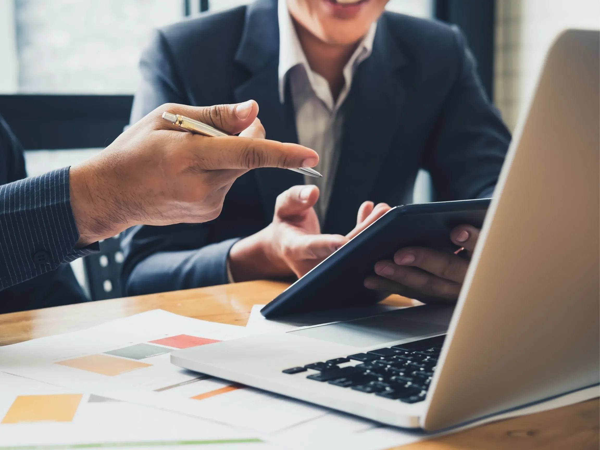 Zwei Menschen sitzen vor einem Laptop und sprechen miteinander