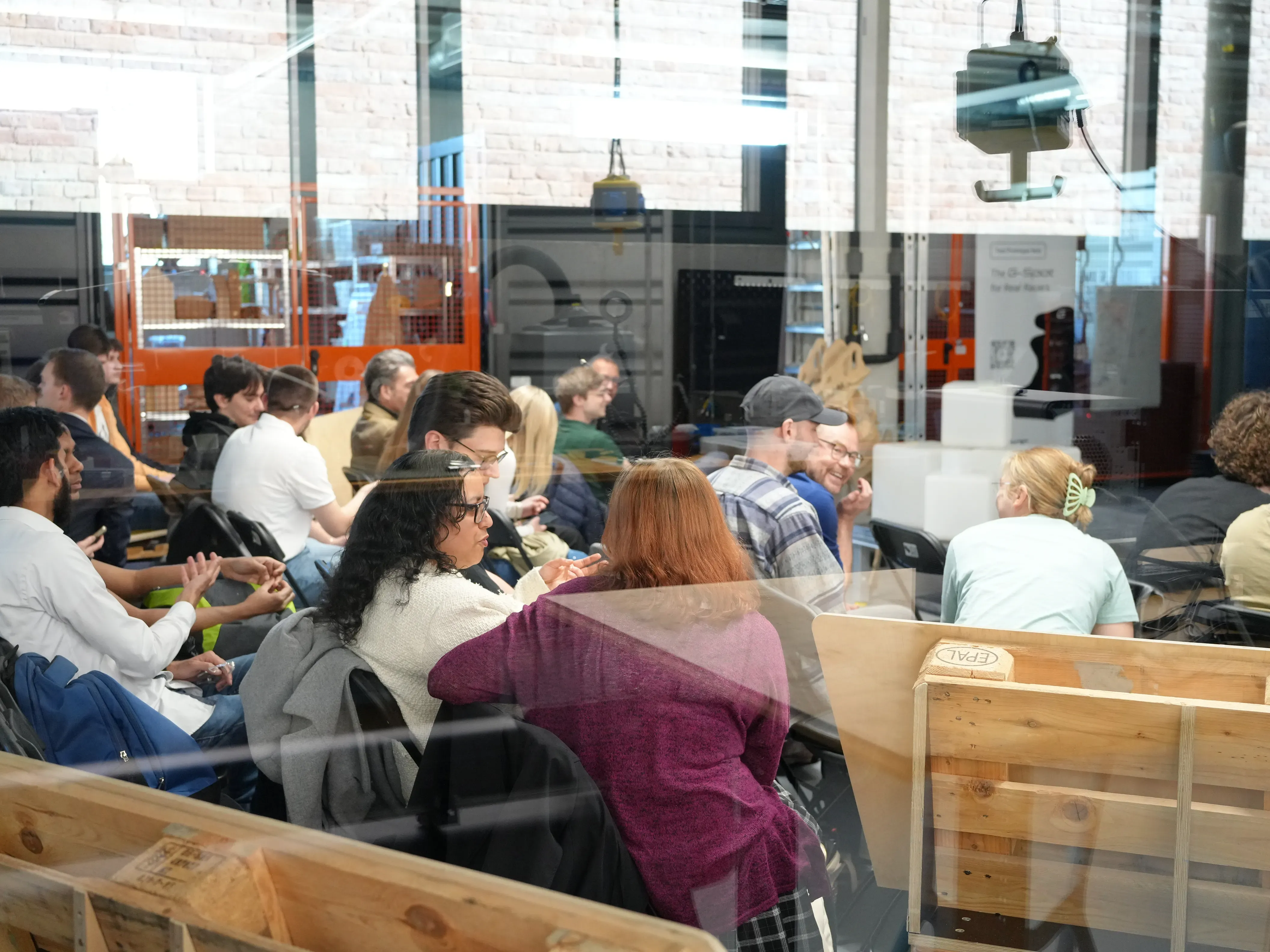 Menschen sitzen auf Stühlen vor einer Bühne 