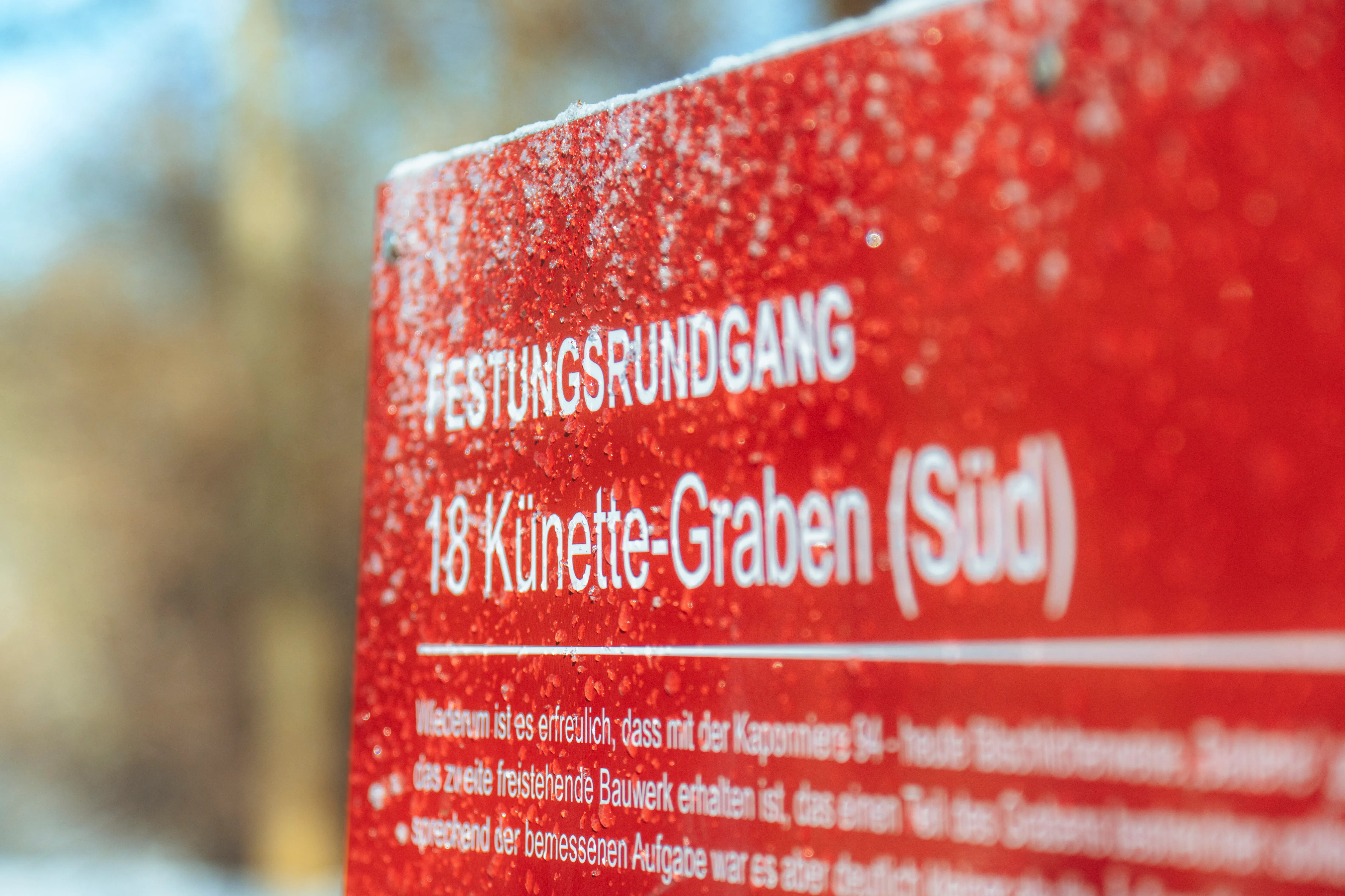 rote Wegtafel mit schrift und verschneit.